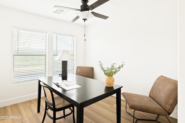 office space with a ceiling fan, baseboards, visible vents, and light wood finished floors