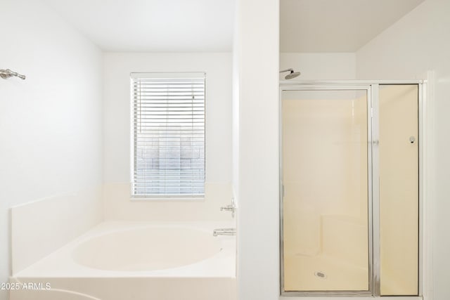 bathroom featuring a shower stall and a garden tub