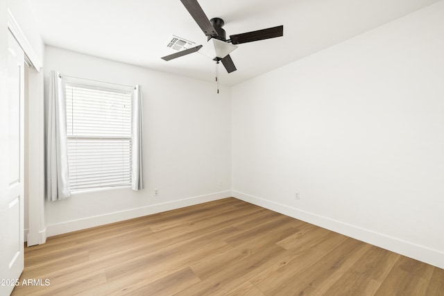 spare room featuring ceiling fan, visible vents, baseboards, and light wood-style flooring