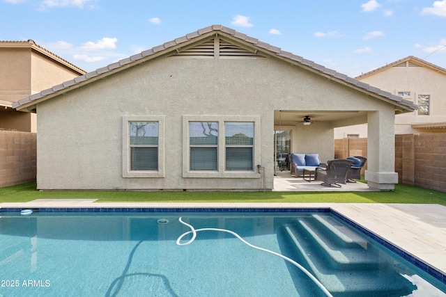 back of property featuring fence, an outdoor pool, stucco siding, a tiled roof, and a patio area