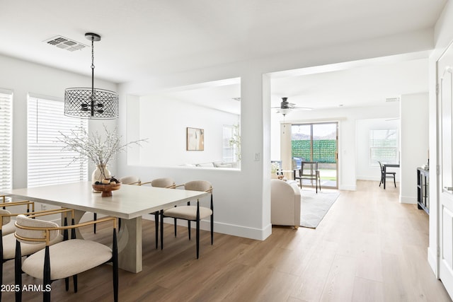 dining area with light wood-style flooring, baseboards, visible vents, and ceiling fan