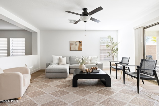 living room with visible vents, a ceiling fan, baseboards, and wood finished floors