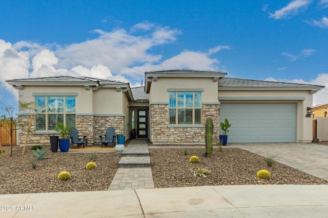 prairie-style house featuring stone siding, stucco siding, driveway, and a garage