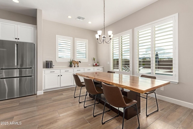 dining area with visible vents, a healthy amount of sunlight, and light wood-style floors