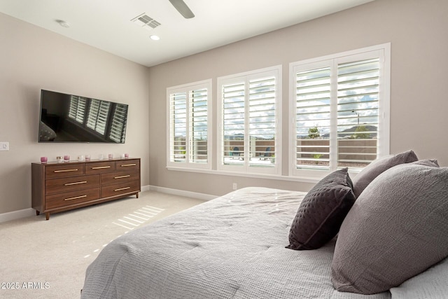 bedroom with visible vents, baseboards, light colored carpet, and ceiling fan