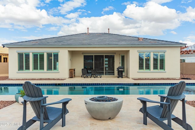 outdoor pool featuring a patio, area for grilling, and an outdoor fire pit