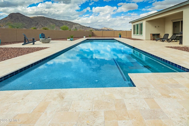 view of swimming pool with a patio, a fenced backyard, and a mountain view