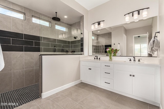 bathroom featuring double vanity, plenty of natural light, a walk in shower, and a sink