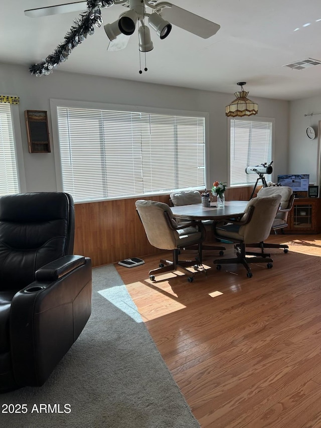 dining room with ceiling fan, a healthy amount of sunlight, and hardwood / wood-style flooring