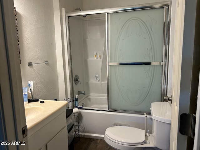 full bathroom with toilet, bath / shower combo with glass door, hardwood / wood-style flooring, and vanity