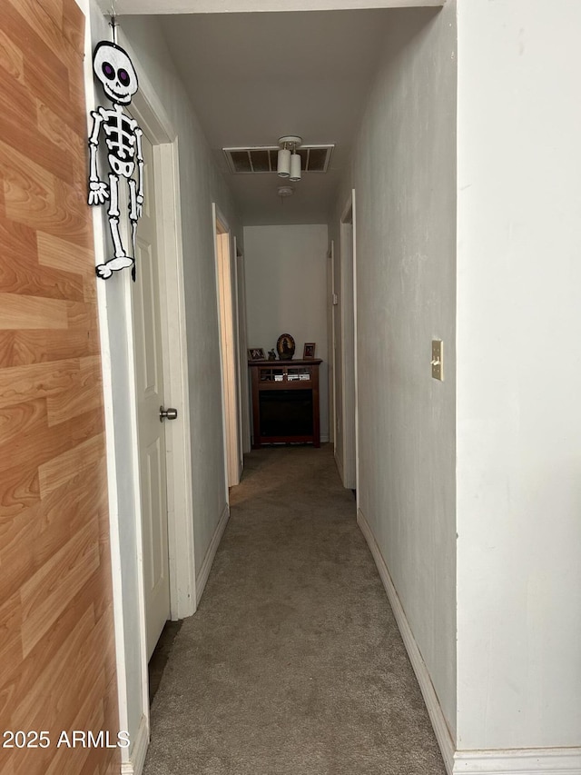 corridor with light colored carpet and wood walls