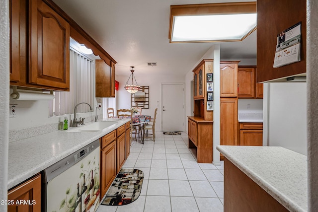 kitchen featuring glass insert cabinets, brown cabinets, stainless steel dishwasher, pendant lighting, and a sink