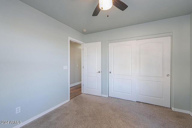 unfurnished bedroom featuring light colored carpet, a closet, and ceiling fan