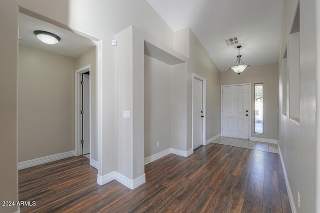 foyer entrance featuring vaulted ceiling and dark hardwood / wood-style floors