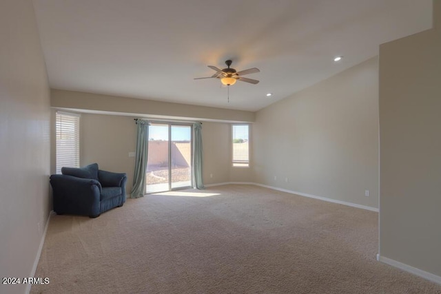 interior space with ceiling fan and light colored carpet