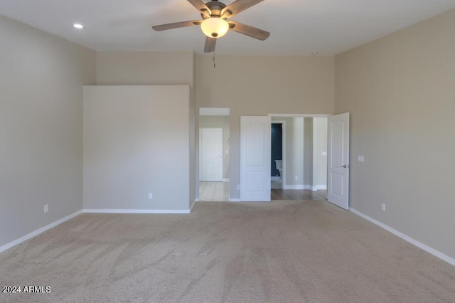 unfurnished room featuring light colored carpet and ceiling fan