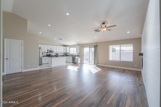 unfurnished living room featuring dark hardwood / wood-style floors, ceiling fan, and lofted ceiling