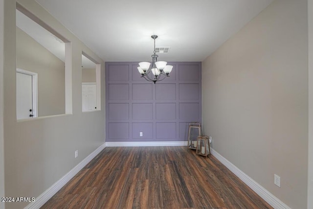 unfurnished dining area with dark hardwood / wood-style floors and a notable chandelier