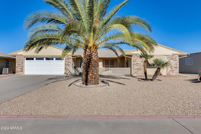 view of front of property with a garage and central AC