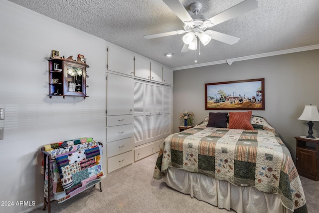 carpeted bedroom featuring ceiling fan, ornamental molding, a textured ceiling, and a closet