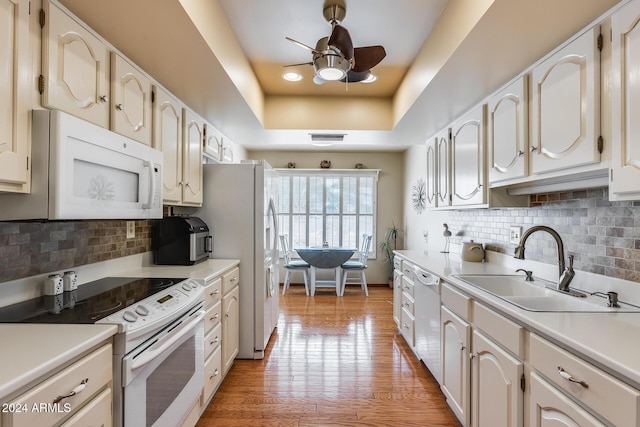 kitchen with decorative backsplash, white cabinets, wood-type flooring, and white appliances