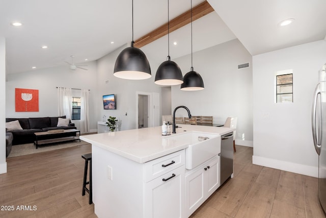 kitchen with light wood-style floors, a center island with sink, visible vents, and stainless steel appliances