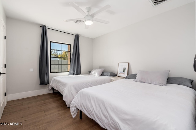 bedroom with a ceiling fan, baseboards, visible vents, and wood finished floors