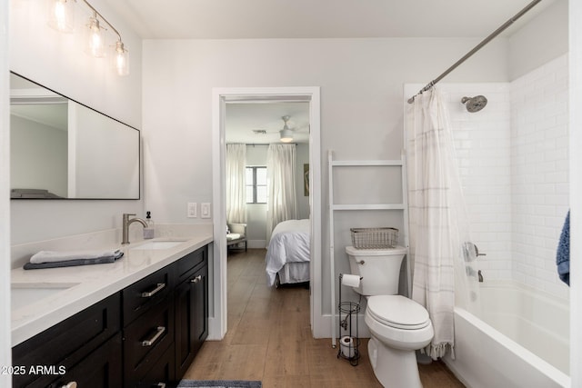 bathroom with toilet, wood finished floors, a sink, double vanity, and shower / bath combo with shower curtain