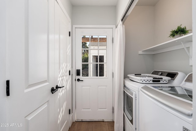 clothes washing area with light wood finished floors and washer and dryer