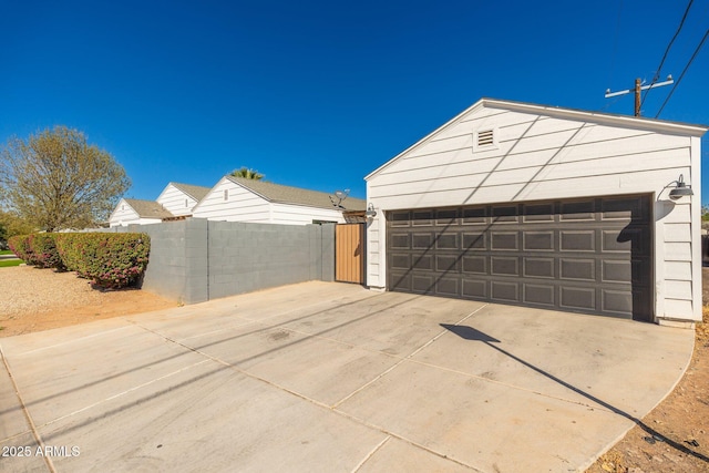 detached garage featuring fence