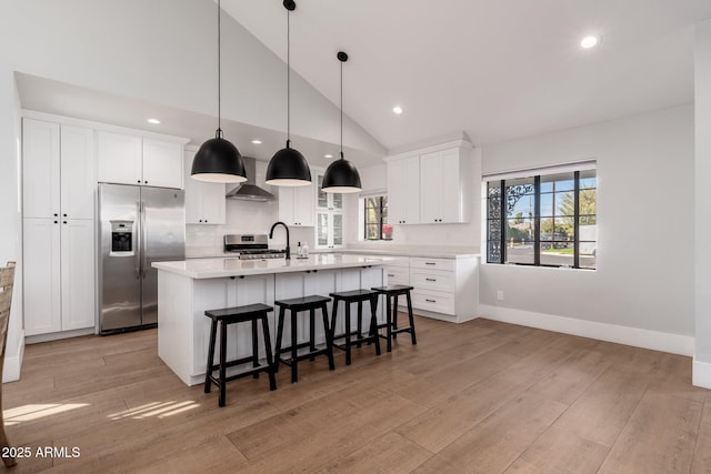 kitchen featuring light wood finished floors, light countertops, appliances with stainless steel finishes, and a center island with sink