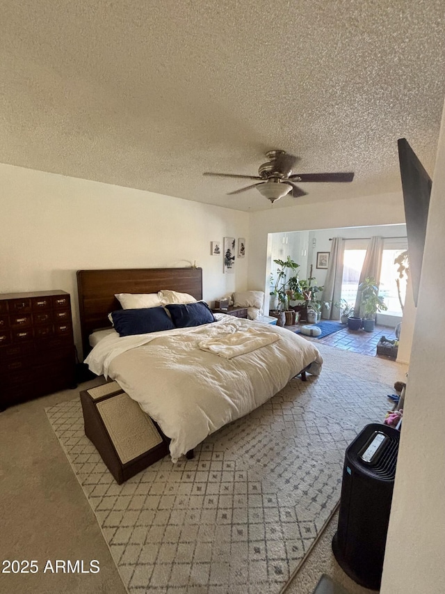 bedroom featuring ceiling fan, access to exterior, carpet, and a textured ceiling