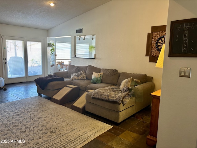 living room featuring lofted ceiling and a textured ceiling