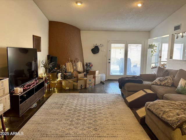 living room featuring lofted ceiling and a textured ceiling