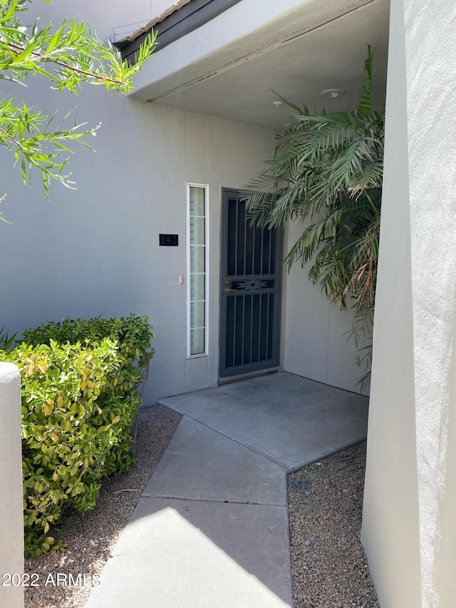 view of exterior entry with a patio area