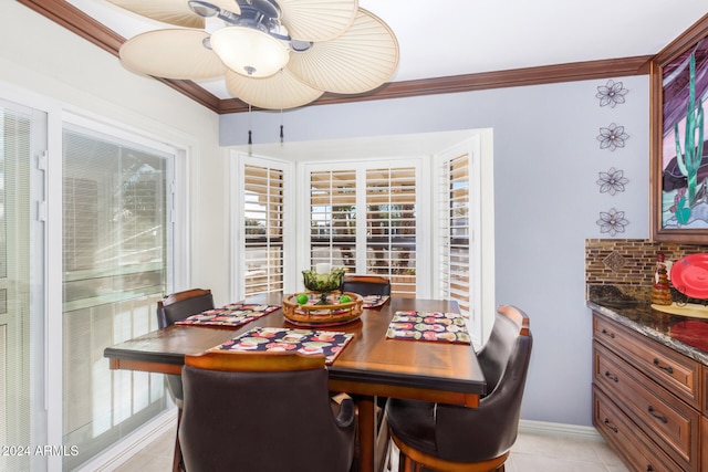 dining area featuring light tile patterned floors, crown molding, and a healthy amount of sunlight