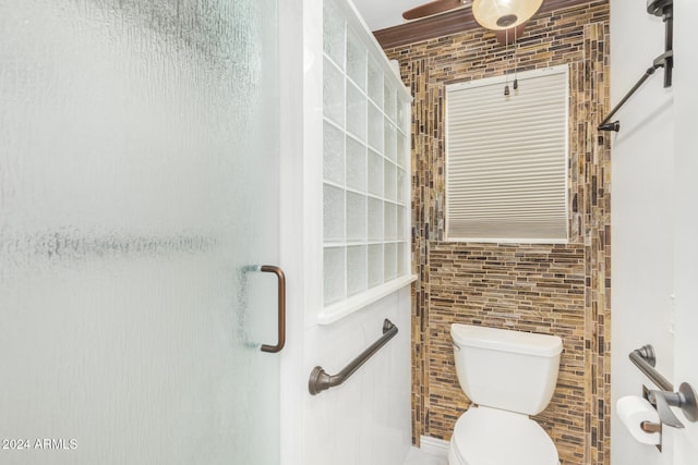 bathroom featuring tile walls, ceiling fan, toilet, and walk in shower