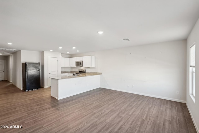 kitchen featuring light wood-type flooring, white cabinetry, stainless steel appliances, and kitchen peninsula