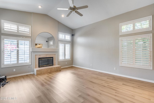 unfurnished living room with a fireplace, light hardwood / wood-style flooring, high vaulted ceiling, and ceiling fan