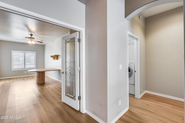 corridor featuring french doors, a textured ceiling, and light hardwood / wood-style floors