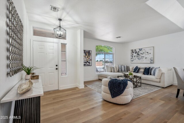 1029 E Ian Dr, Phoenix, AZ 85042 - entryway featuring a chandelier, light wood-style floors, and baseboards