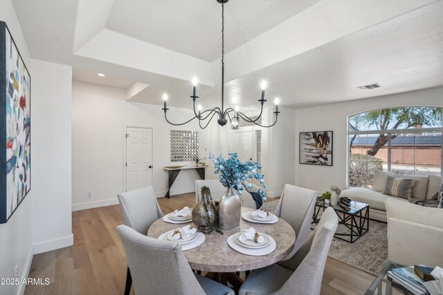 1029 E Ian Dr, Phoenix, AZ 85042 - dining area with a chandelier, light wood-style flooring, and baseboards