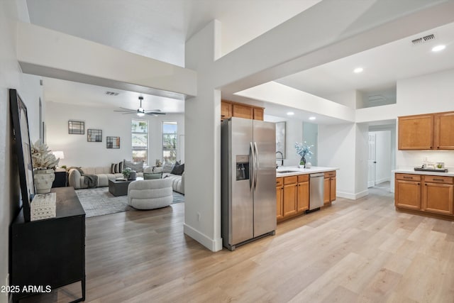 1029 E Ian Dr, Phoenix, AZ 85042 - kitchen featuring appliances with stainless steel finishes, light wood-type flooring, light countertops, open floor plan, and recessed lighting