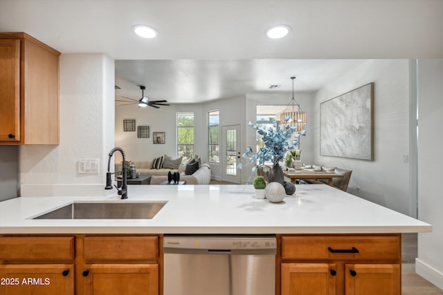 1029 E Ian Dr, Phoenix, AZ 85042 - kitchen with stainless steel dishwasher, a sink, open floor plan, light countertops, and a peninsula