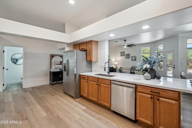 1029 E Ian Dr, Phoenix, AZ 85042 - kitchen featuring stainless steel appliances, a sink, a peninsula, light wood-type flooring, and light countertops