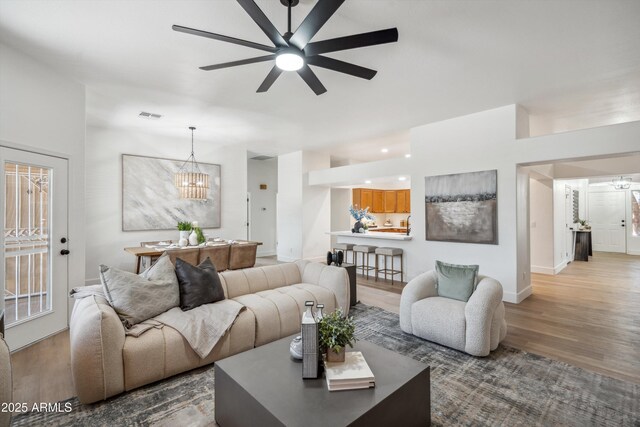 1029 E Ian Dr, Phoenix, AZ 85042 - living room with a chandelier, wood finished floors, a ceiling fan, and baseboards