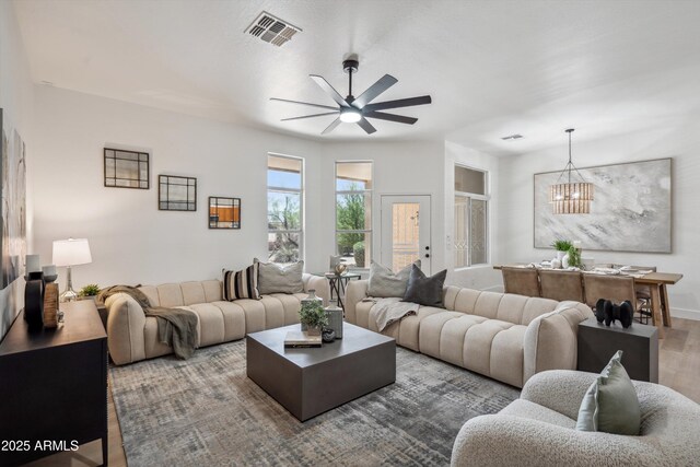 1029 E Ian Dr, Phoenix, AZ 85042 - living room featuring wood finished floors, a chandelier, a ceiling fan, and baseboards