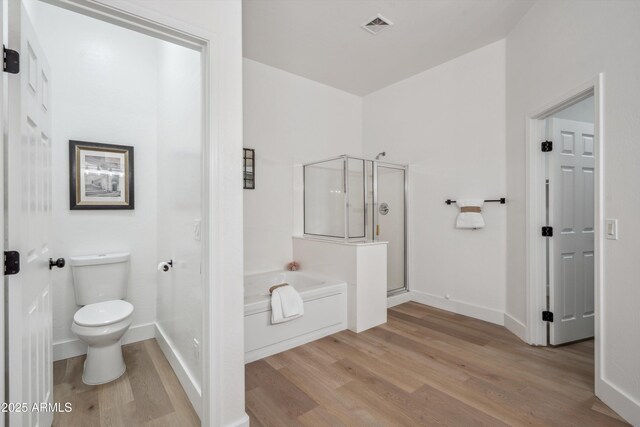 1029 E Ian Dr, Phoenix, AZ 85042 - bathroom with wood finished floors, a bath, a stall shower, toilet, and baseboards