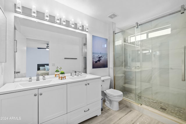 bathroom featuring wood-type flooring, toilet, an enclosed shower, vanity, and ceiling fan