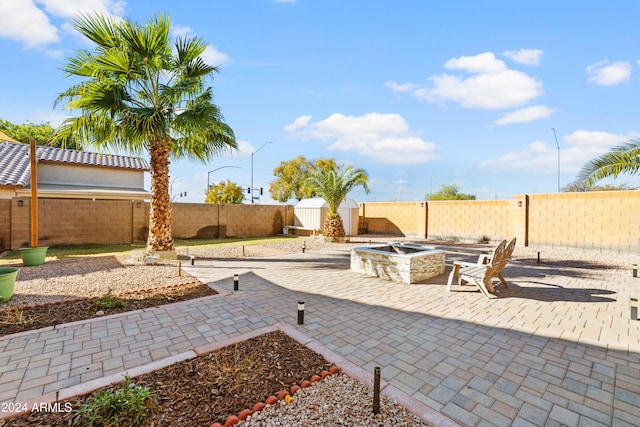 view of patio / terrace featuring a storage shed and a fire pit